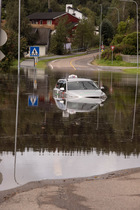 Taxi submerged in floodwater after heavy rain, Follo, Norway. August, 2023.