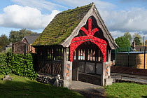 Eardisley Church lych gate adorned with poppies to mark Remembrance Day, Herefordshire, England, UK, November 2023. Built by Ewan Christian in 1863.