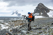 Photographer Tim Laman photographing at Half Moon Island, South Shetland Islands, Antarctica. February, 2023. Model Released.