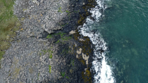 Drone tracking shot of rocky shore on coast, Northumberland, England, UK, North Sea, April.