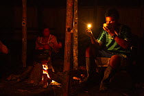 Kichwa villagers drinking traditional Guayusa tea before sunrise in Anangu, Yasuni National Park, Orellana Province, Ecuador. Kichwa drink this tea every morning and share their dreams with each other...
