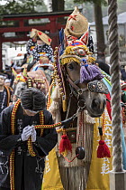 Decorated heavy horse being ridden by bowing rider, with bowing handler standing beside them Chagu Chagu Umakko festival, Iwate Prefecture, Japan, June.   In 1996, the sound of the bells worn by the...