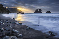 Sun setting behind mountains beside Atlantic coast, Playa de Benijo, Tenerife, Canary Islands, March 2023.