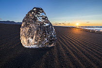 Chunk of ice sitting on Diamond Beach at sunrise, Jokulsarlon, Iceland, September 2017.