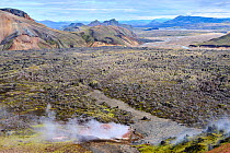 View of rhyolite mountains and solidified lava fields with steam from geothermal vents, Landmannalaugar volcanic massif, Fjallabak Nature Reserve, Iceland. September, 2023.