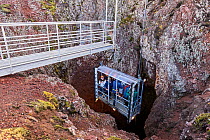 Tourists in open cable lift descending into Thrihnukagigur volcano, a dormant volcano now used for tours, Iceland. September, 2023. EDITORIAL USE ONLY.