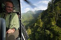 View from helicopter of the Foja Mountains rain forest with  expedition researcher looking out for possible landing sites, Foja Mountains, West Papua. June, 2007.