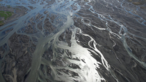 Aerial tracking shot of braided glacial river, south Iceland. June.
