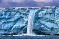 RF - Waterfall caused by melt water, Austfonna Polar Ice Cap, Svalbard, Norway, Arctic Ocean. September, 2023. (This image may be licensed either as rights managed or royalty free.)