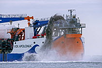 Trailing suction hopper dredger Vox Apolonia of Van Oord, Dutch maritime contracting company specialized in dredging, rainbowing along Zeeland coast, Netherlands, North Sea. October, 2023.