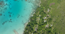 Aerial shot of a coastal community and adjacent ocean with coral reef pinnacles, Murat LLG, New Ireland, Papua New Guinea.
