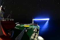 German research vessel SONNE at night shining huge spotlight on the ocean, during an expedition Cruise SO285 in the South Atlantic, specifically in the Benguela upwelling region off the coast of South...