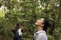 Primatologist and her assistant searching for monkeys in the forest canopy, Marimonda, Necocli, Colombia. January, 2022.