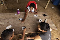 Primatologist playing an animal track identification game with two people from the local community, Marimonda, Necocli, Colombia. January, 2022.