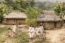 Group of local people from the Wiwa tribe standing outside their homes in Kemakumake village, Sierra Nevada de Santa Marta, Colombia. December, 2021.