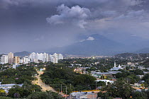 The city of Santa Marta below the slopes of the Sierra Nevada de Santa Marta under a dark sky, Colombia. November, 2021.