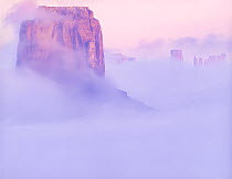 Merrick Butte and Sentinal Mesa shrouded in fog, Monument Valley, Navajo Tribal Park, Arizona, USA.