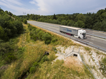 Aerial view of a wildlife underpass below the A89 highway with truck driving by above, Correze, France. July, 2018.