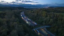 Aerial view of a wildlife crossing over the A7 highway at dusk, built in 2011, city of  Salaise-sur-Sanne in the distance, Drome, France. November, 2023.