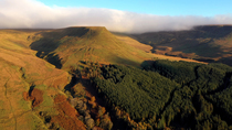 Aerial tracking shot of mountainous landscape, Brecon Beacons National Park, Wales, UK.