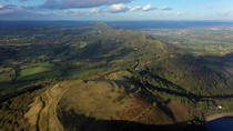 Aerial tracking shot of British Camp Hill Fort and the Malvern Hills AONB, Herefordshire and Worcestershire, UK.