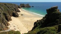 Drone tracking shot of people on Pedn Vounder Beach, Porthcurno, Cornwall, UK.