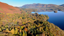Aerial shot of Derwentwater and surrounding woodland. In the background is the Skiddaw mountain range. Keswick, Lake District National Park, Cumbria, UK.