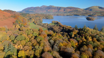 Drone shot of Derwentwater and its wooded edges. In the background is the Skiddaw mountain range. Keswick, Lake District National Park, Cumbria, UK.