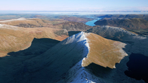 Drone tracking shot along Swirral Edge which leads to Helvellyn. In the background is Ullswater lake. Lake District National Park, Cumbria, UK.