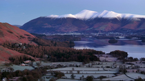 Aerial tracking shot of Derwentwater, Borrowdale valley and the Skiddaw mountain range, Keswick, Lake District National Park, Cumbria, UK.