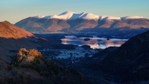 Aerial tracking shot of Derwentwater, Borrowdale valley and the Skiddaw mountain range, Keswick, Lake District National Park, Cumbria, UK.
