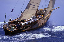 A classic gaffer rides over a wave during a race at Antigua Classic Race Week, Caribbean. 1998
