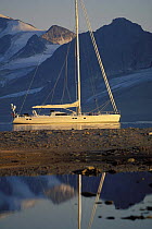 88ft foot sloop "Shaman" anchored beneath the mountains of Spitsbergen on a calm day. Svalbard Archipelago, Norway, 1998. Property Released.
