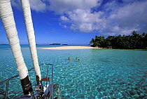 From aboard the 88 foot sloop, "Shaman", people swimming in the clear waters off a small island in the Vava'u group, Tonga, South Pacific. Model and Property Released.