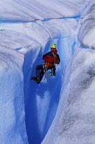 Speleologist ice climbing down deep cave in the Perito Moreno glacier, Patagonia, Argentina