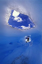 A person standing at the end of a tunnel formed by an ice melt glacial river, Perito Moreno glacier, Patagonia, Argentina