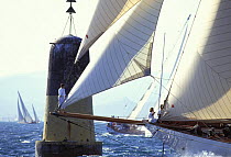 Bowman on the bowsprit of Schooner "Adix" sailing close by a large North cardinal mark at La Nioulargue, St Tropez, South France 1993.