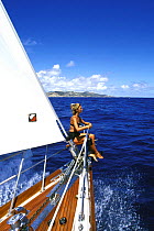 A member of the crew enjoying cruising from the bow of "Realite", St Maarten, Caribbean.