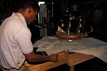 A model ship maker working from detailed plans to recreate traditional sailing ships, Mauritius