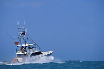 A large sport fishing boat heading out to sea from Key West, Florida Keys, Florida, USA.