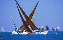Farr 40's cross tacking upwind while fleet with spinnakers flying heads downwind in the background during Key West Race Week, Florida, USA