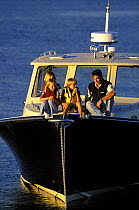 Family cruising aboard a Pearson True North 38 motorboat in Narragansett Bay, Rhode Island, New England, USA. Model released.