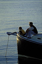 Father and son on the bow while cruising with family aboard a Pearson True North 38 motorboat in Narragansett Bay, Rhode Island, New England, USA.