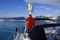 Breakfast and thermal clothing for the helmsman of 88ft sloop "Shaman", during summer, Svalbard, Norway, 1998