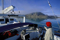 Helming 88ft sloop "Shaman" through the calm waters and mountains of Spitsbergen, Svalbard, Norway, 1998.