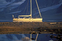 The 88ft sloop "Shaman" anchored in calm waters beneath the mountains of Spitsbergen, Svalbard, Norway, 1998. Property Released.