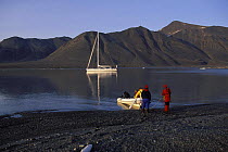 Crew of 88ft sloop "Shaman" returning to their boat in an inflatable tender at 2am. Summertime in Spitsbergen, Svalbard, Norway, 1998.