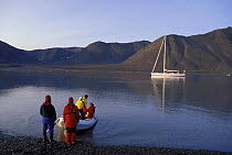 Crew of 88ft sloop "Shaman" returning to their boat in an inflatable tender at 2am. Summertime in Spitsbergen, Svalbard, Norway 1998.