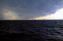 Yacht racing with approaching squall.