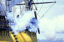 Smoke from a firing cannon on a tall ship.